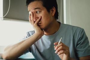 Aziatische man is wanhopig op zoek naar rookverslaving