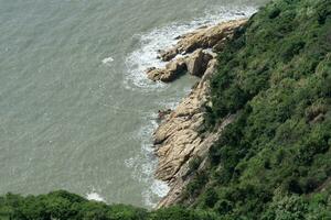 spindrift en rotsen door de zee, foto in Taizhou, zhejiang.