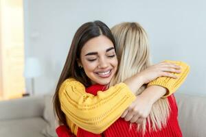 openhartig verschillend meisjes het beste vrienden omarmen staand binnenshuis, dichtbij omhoog tevreden Dames gezicht genieten inschrijving moment gemist blij naar zien elk andere na lang scheiding, vriendschap warm relaties concept foto