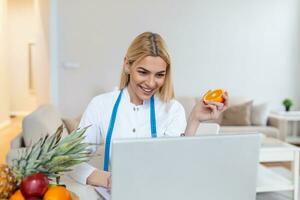 dokter voedingsdeskundige schrijven geval geschiedenis in de kantoor. jong vrouw diëtist voorschrijven recept. vrouw voedingsdeskundige zittend Bij tafel met laptop foto