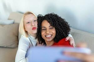 schot van een twee vrouw vrienden nemen selfie in de appartement. mijn kamergenoten. schot van twee jong Dames nemen een selfie terwijl zittend Bij huis. gedeeld leven huisgenoten maken een selfie foto