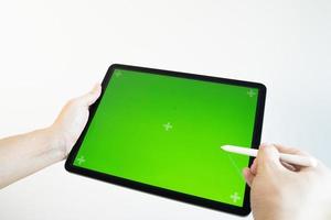 hand tekent een potlood op een tablet met een chromakey op het scherm.