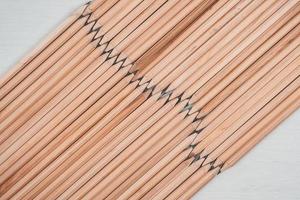 houten potloden gerangschikt zigzag op witte achtergrond.