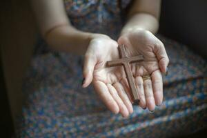 vrouwenhand met kruis .concept van hoop, geloof, christendom, religie, kerk online. foto
