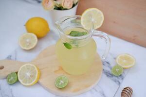 limonade met vers citroen en munt bladeren Aan een wit achtergrond foto