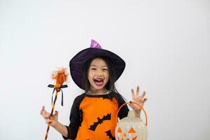 grappig kind meisje in heks kostuum voor halloween met pompoen en heks bezem. foto