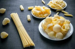 divers types van pasta Aan de donker achtergrond foto