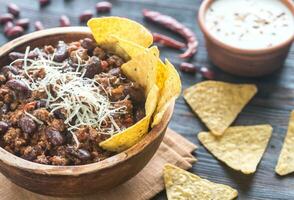 kom van Chili con carne met tortilla chips foto