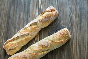 twee stokbrood Aan de houten achtergrond foto