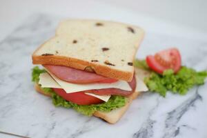 belegd broodje met ham, kaas, tomaat en sla achtergrond foto