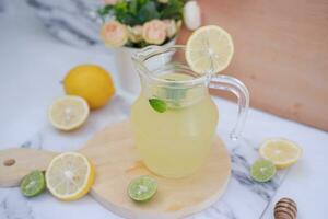 limonade met vers citroen en munt bladeren Aan een wit achtergrond foto