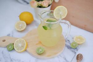 limonade met vers citroen en munt bladeren Aan een wit achtergrond foto