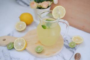 limonade met vers citroen en munt bladeren Aan een wit achtergrond foto