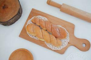 brood donuts Aan de houten tafel met houten rollend pin. foto
