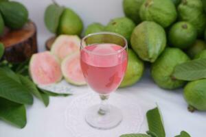 vers guava sap in een glas en vers guava fruit. foto