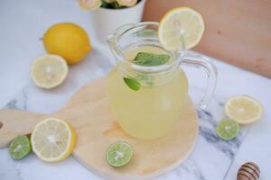 limonade met vers citroen en munt bladeren Aan een wit achtergrond foto