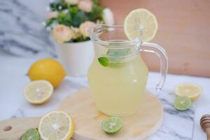 limonade met vers citroen en munt bladeren Aan een wit achtergrond foto