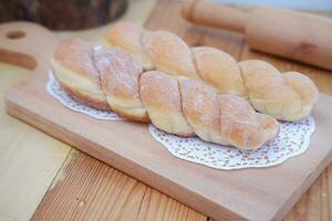 brood donuts Aan de houten tafel met houten rollend pin. foto