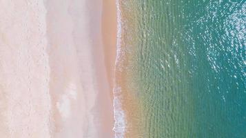 luchtfoto van strand met schaduw smaragdblauw water en golfschuim op tropische zee foto