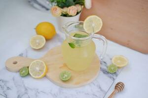limonade met vers citroen en munt bladeren Aan een wit achtergrond foto
