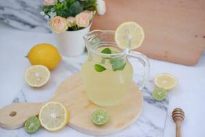 limonade met vers citroen en munt bladeren Aan een wit achtergrond foto