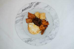 gebakken tofu met gebakken ei en pinda saus Aan wit marmeren tafel foto