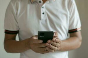 mannetje hand- gebruik makend van mobiel telefoon foto