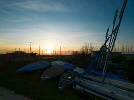 het zeilen rubberboten en boot masten Bij zonsondergang foto