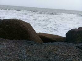 visie van de golven en rotsen Aan de strand foto