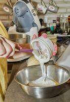 chef voegt toe creme fraichche naar een kom van taart ingrediënten foto