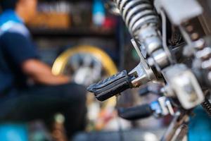 automonteur die motorfiets in fietsreparatiewerkplaats repareert foto