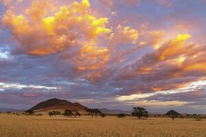 oranje gekleurde wolken Bij zonsopkomst in namib woestijn foto