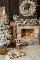 de interieur van een kamer met een haard, Kerstmis bomen met kunstmatig sneeuw en slingers, een deken en een dienblad met heet drankjes. de magisch atmosfeer van kerstmis. foto
