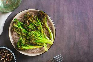 gebakken groen broccoli spruiten Aan een bord Aan de tafel top visie foto