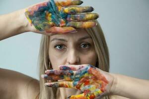 mooi jong meisje met handen geschilderd, kleurrijk plezier. creatief en grappig ontwerp foto