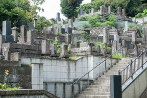 Japan begraafplaats. grafsteen en boeddhistisch standbeeld. foto