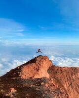 een Mens wie was jumping bovenstaand berg rots foto