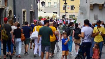 Warschau, Polen. 29 juli 2023. menigte van mensen wandelen Aan een straat. een menigte in beweging tegen een achtergrond van een stedelijk oud stad landschap. foto