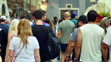 Warschau, Polen. 29 juli 2023. menigte van mensen wandelen Aan een straat. een menigte in beweging tegen een achtergrond van een stedelijk oud stad landschap. foto