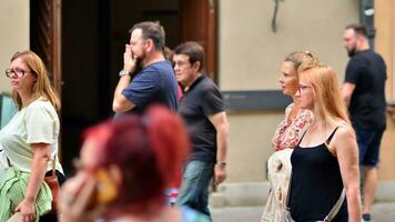 Warschau, Polen. 29 juli 2023. menigte van mensen wandelen Aan een straat. een menigte in beweging tegen een achtergrond van een stedelijk oud stad landschap. foto