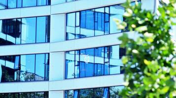 eco architectuur. details van facade glas en aluminium panelen Aan gebouw. groen boom en modern kantoor gebouw. de harmonie van natuur en moderniteit. foto