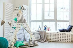 elegant modern kinderen kamer. kinderen wigwam in kinderen kamer. groot houten ster lamp. interieur Scandinavisch stijl. foto