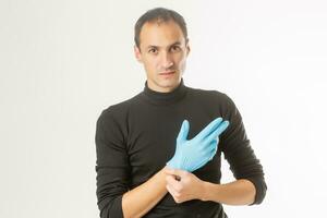 man latex chirurgische handschoen te zetten foto
