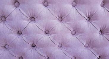 lila velours achtergrond met gewatteerd bekleding in chesterfield stijl detailopname. foto