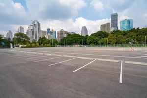 lege parkeerplaats met stad op de achtergrond en mooie blauwe lucht foto