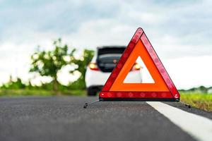 problemen auto en een rode driehoek waarschuwingsbord op de weg foto