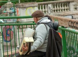 Wenen, Oostenrijk - 05.13.2023 een straat musicus Toneelstukken de knop accordeon. foto