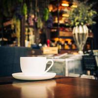 hete latte koffie in witte kop op tafel in restaurant en café foto