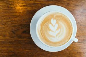 hete latte koffie in witte kop op tafel in restaurant en café foto