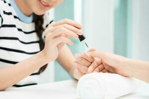 vrouw te ontvangen zorg onderhoud door professioneel schoonheidsspecialist manicure Bij spa centrum. nagel schoonheid salon gebruik nagel het dossier voor beglazing behandeling. manicure maken nagel klant naar mooi. lichaam zorg spa behandeling foto